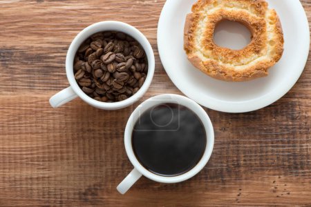 Téléchargez les photos : Tasses à café avec beignet sur fond en bois - en image libre de droit