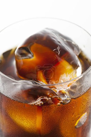 Foto de Vista de cerca de la bebida fría de cola con cubitos de hielo en vidrio sobre fondo blanco. - Imagen libre de derechos