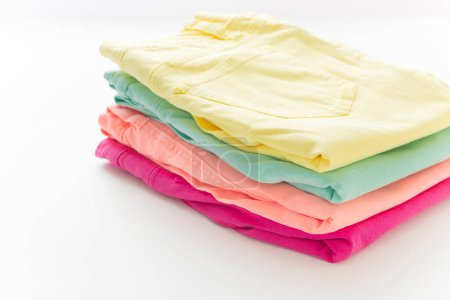 Photo for A stack of folded shirts on  white  background, close up - Royalty Free Image