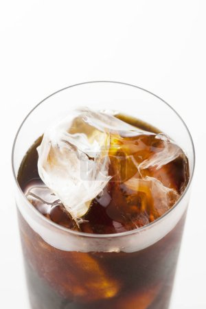 Foto de Vista de cerca de la bebida fría de cola con cubitos de hielo en vidrio sobre fondo blanco. - Imagen libre de derechos