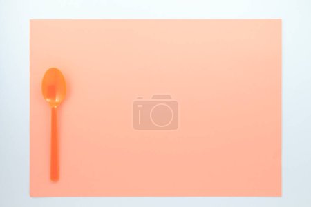 Téléchargez les photos : Vue de dessus de cuillère en plastique rouge sur fond beige - en image libre de droit