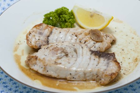 Foto de Plato de pescado al horno con brócoli y un limón - Imagen libre de derechos