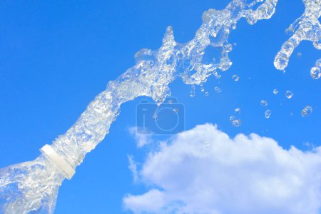 Foto de Salpicadura de agua de la botella en el fondo del cielo azul - Imagen libre de derechos