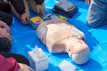 Photo for Resuscitation training using first-aid dummy and people - Royalty Free Image