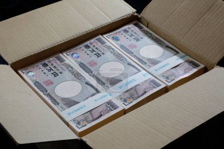Téléchargez les photos : Billets en yens japonais dans une boîte en carton - en image libre de droit