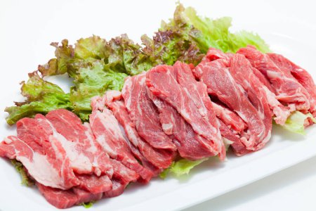 Photo for Raw meat pieces and lettuce leaves - Royalty Free Image