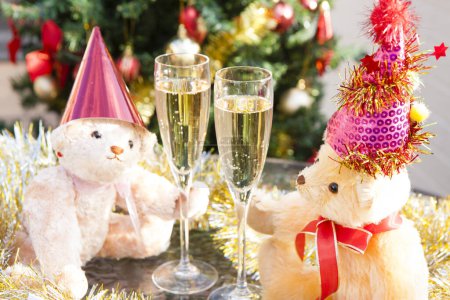 Téléchargez les photos : Vue rapprochée des verres à champagne et des ours en peluche drôles dans les chapeaux de Noël - en image libre de droit