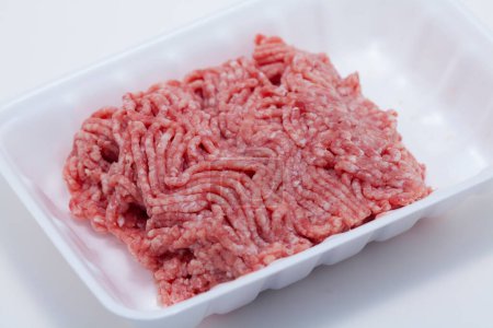 Téléchargez les photos : Viande hachée dans un plateau en plastique sur fond, gros plan - en image libre de droit