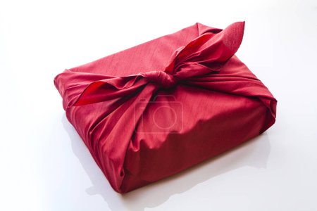 Geschenk eingewickelt in ein Furoshiki auf weißem Hintergrund