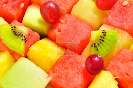 Téléchargez les photos : Gros plan de salade de fruits frais avec pastèque, ananas, raisins et kiwis - en image libre de droit