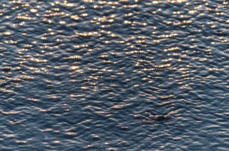 Téléchargez les photos : Surface de l'eau avec des ondulations au coucher du soleil pittoresque - en image libre de droit