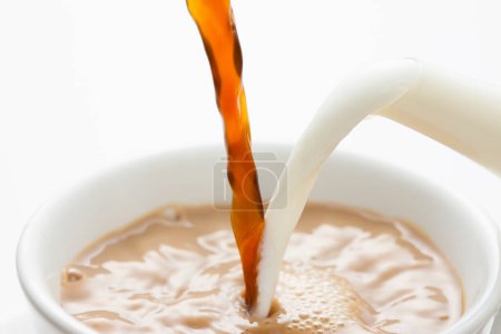 Foto de Una taza de café que se vierte con leche sobre el fondo, de cerca - Imagen libre de derechos