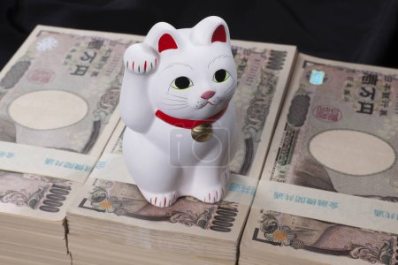 Foto de Billetes de yen japoneses y Maneki-neko gato, Simbolizando la suerte y la riqueza - Imagen libre de derechos