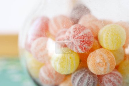 Téléchargez les photos : Bonbons gelée colorés et pot en verre transparent sur la table - en image libre de droit