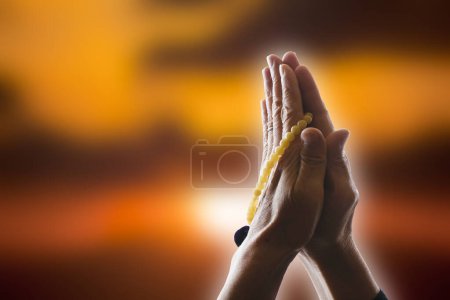 Praying woman with hands and palms together holding rosary,  concept for faith, spirituality and religion