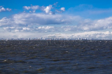 Foto de Mar con nubes y vista de la ciudad en el fondo - Imagen libre de derechos