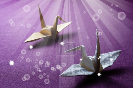 Foto de Dos grúas de origami de papel con estrellas púrpuras - Imagen libre de derechos