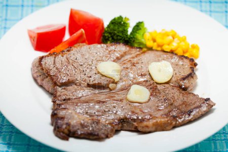 Téléchargez les photos : Vue rapprochée de délicieux steak grillé et légumes sur assiette blanche - en image libre de droit