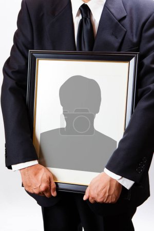 Vue rapprochée de la personne tenant un cadre funéraire avec silhouette homme 