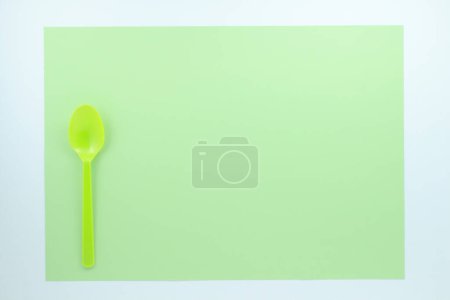 Foto de Vista superior de la cuchara de plástico brillante sobre fondo verde - Imagen libre de derechos