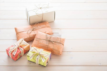 Téléchargez les photos : Trois cadeaux emballés sur une table en bois - en image libre de droit