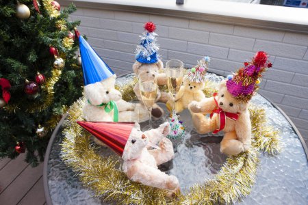Foto de Vista de cerca de copas de champán y divertidos osos osos de peluche en sombreros de Navidad - Imagen libre de derechos