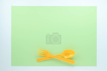 Photo for Top view of bright plastic cutlery on green background - Royalty Free Image