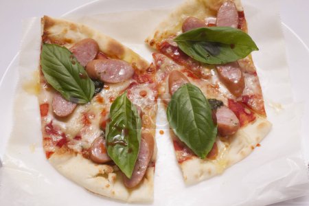 Téléchargez les photos : Pizza au jambon, fromage, feuilles de basilic - en image libre de droit