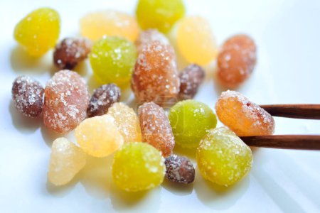 Photo for Close up shot of sweet candied fruits and chopsticks - Royalty Free Image