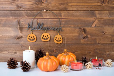 Photo for Halloween composition with pumpkins and burning candles on wooden surface - Royalty Free Image