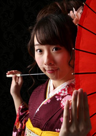 Téléchargez les photos : Portrait de belle jeune femme japonaise en kimono traditionnel avec parapluie en papier antique - en image libre de droit