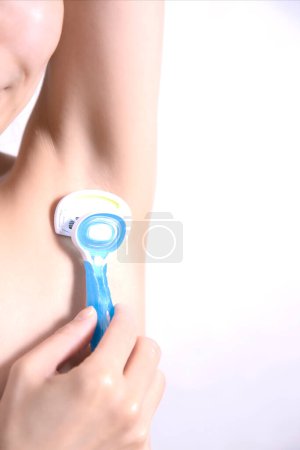 Photo for Closeup Of Asian Female Shaving Armpits Removing Underarms Hair With Safety Razor - Royalty Free Image