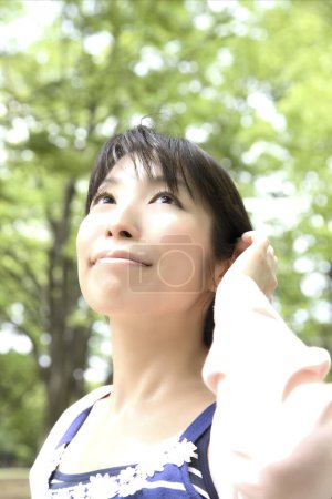 Téléchargez les photos : Jeune femme japonaise étirant pendant la promenade dans le parc - en image libre de droit