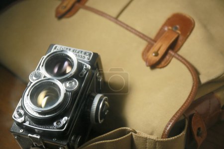 Téléchargez les photos : Vieil appareil photo reflex à double objectif Rolleiflex devant un sac à main en cuir marron - en image libre de droit
