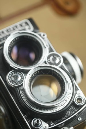 Foto de Antigua cámara réflex doble lente Rolleiflex delante del bolso de cuero marrón - Imagen libre de derechos