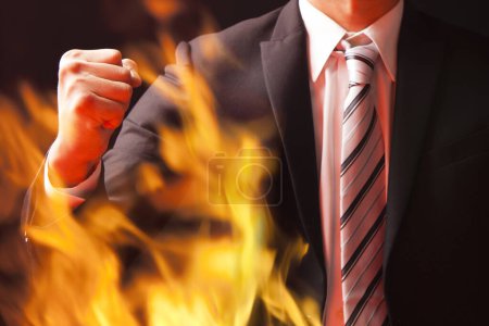 Téléchargez les photos : Homme d'affaires en costume tenant la flamme sur fond noir - en image libre de droit
