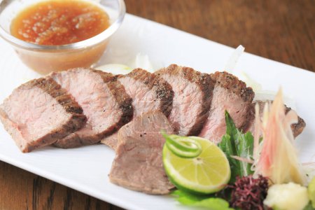 Photo for Delcious sliced baked meat with lime and sauce - Royalty Free Image