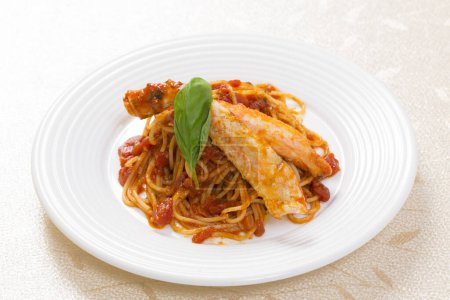 Téléchargez les photos : Vue rapprochée des spaghettis à la sauce tomate et aux feuilles de basilic sur assiette blanche - en image libre de droit