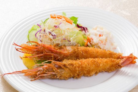 Téléchargez les photos : Vue rapprochée de crevettes frites et salade de légumes sur plat blanc - en image libre de droit