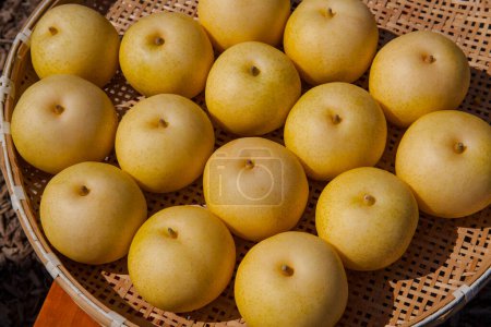Photo for A basket of yellow pears sitting on a table - Royalty Free Image