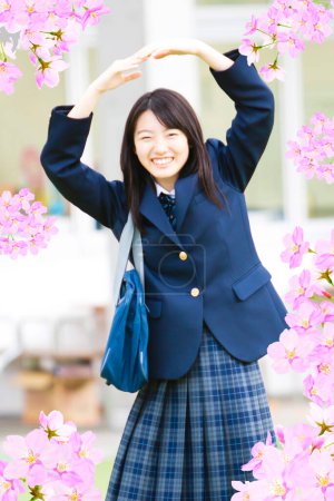 Foto de Retrato de una hermosa colegiala japonesa en el marco de flores de cerezos florecientes - Imagen libre de derechos