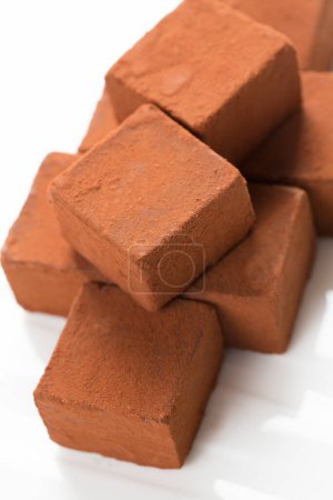 Foto de Pila de cubos de chocolate en una superficie blanca - Imagen libre de derechos