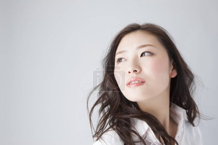 Téléchargez les photos : Portrait de belle jeune femme japonaise en vêtements élégants sur fond blanc - en image libre de droit