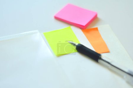 Foto de Notas adhesivas de colores con pluma sobre fondo de mesa blanco - Imagen libre de derechos