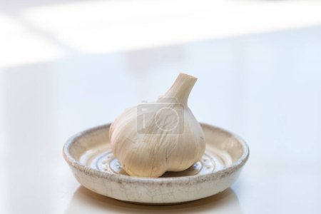 Photo for Bowl of garlic on a white table - Royalty Free Image