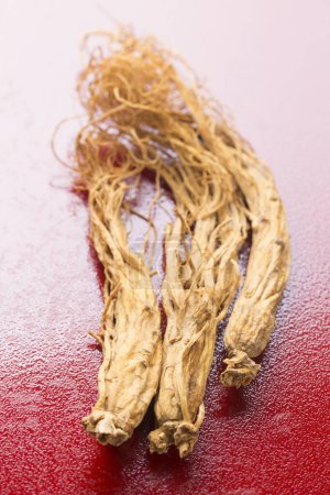 Photo for Bunch of dried ginsen root on red background - Royalty Free Image