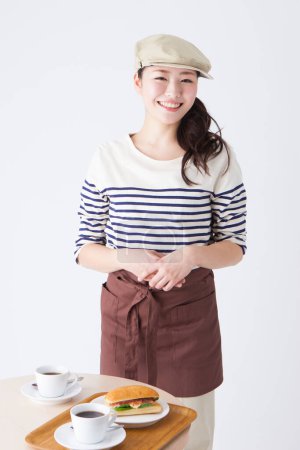 Téléchargez les photos : Portrait de la belle jeune serveuse japonaise en vêtements élégants à la cafétéria - en image libre de droit