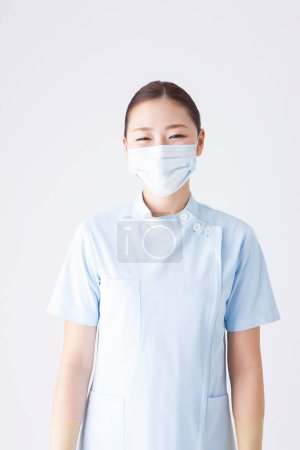 Téléchargez les photos : Portrait de belle jeune japonaise femme médecin en uniforme avec masque respiratoire sur fond blanc - en image libre de droit