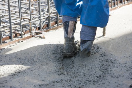 Photo for Worker arranging concrete screed at the construction site - Royalty Free Image