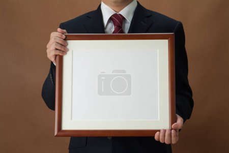 Téléchargez les photos : Photo recadrée de l'homme d'affaires tenant tableau noir vierge avec espace de copie pour le message - en image libre de droit